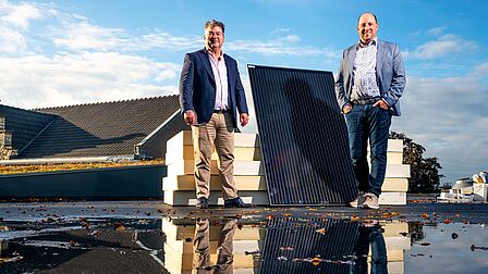 Wethouders Leunissen en Braun op het dak van MFC de Auw Sjoeel waar zonnepanlen worden gelegd. 