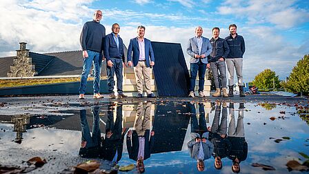 Wethouder Leunissen en Braun op het dak van MFC de Auw Sjoeel waar zonnepanelen worden gelegd met links de projectleiders van gemeente Voerendaal en rechts de projectleiders van Eussen Bouw en Elektro Bouw